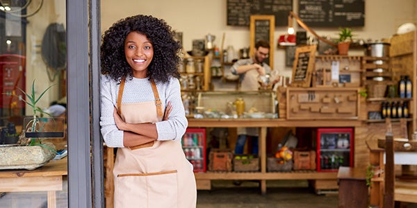 Owner of small business standing in front of store