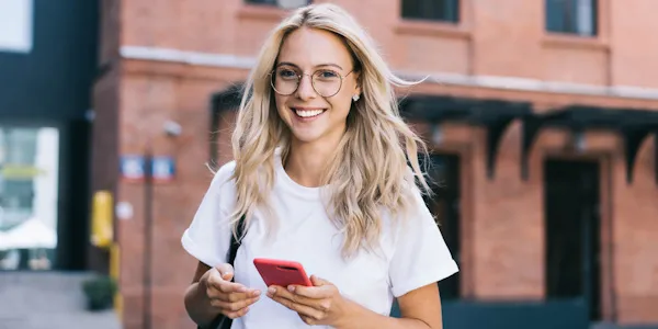 Millennial smiles while holding phone